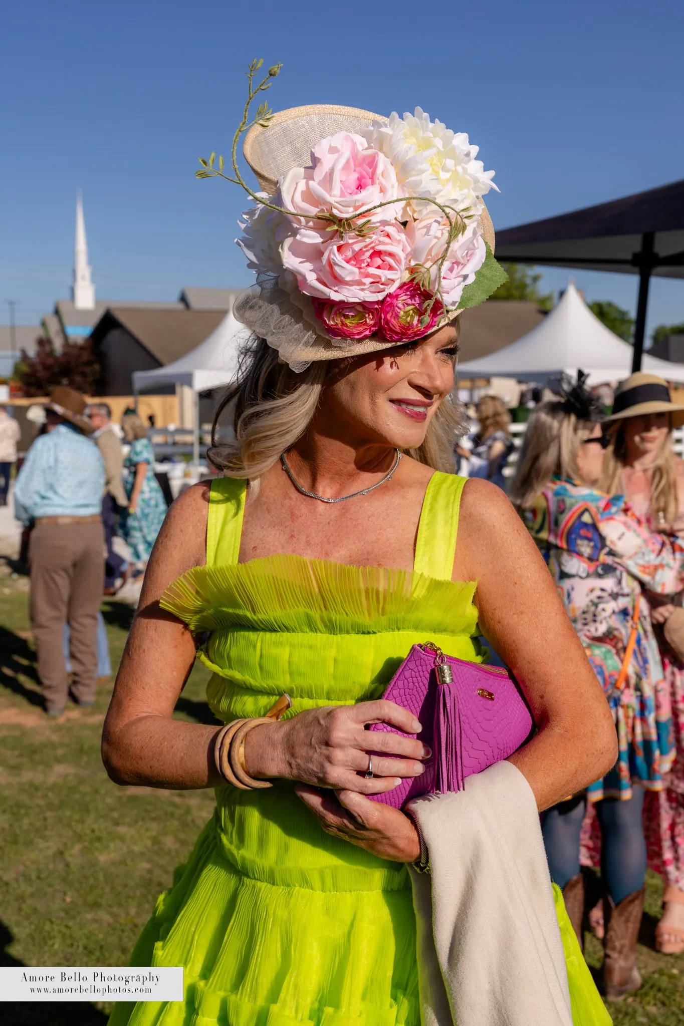 A guest in a lime green dress and floral fascinator