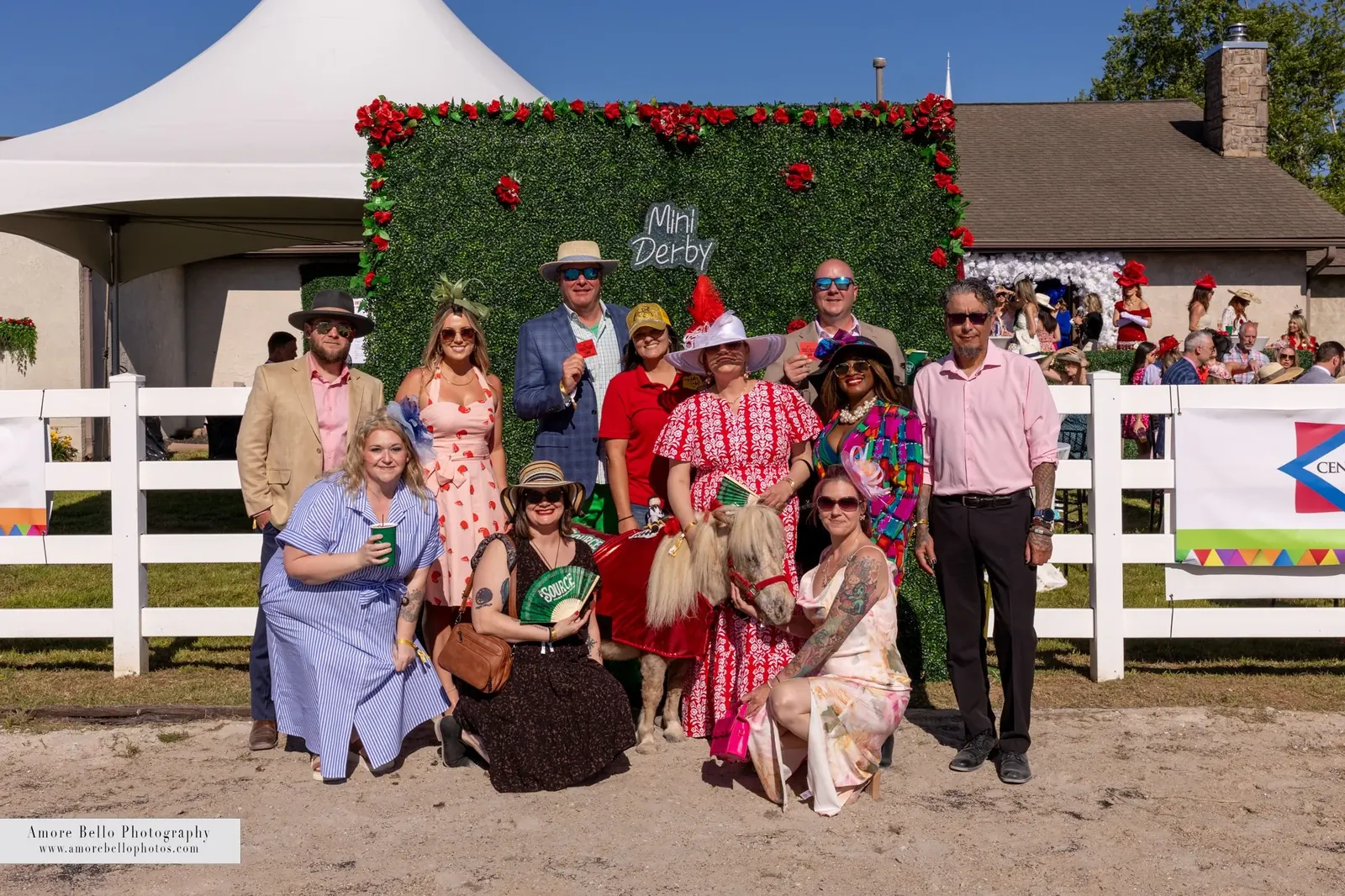 Guests in Derby attire at the Mini Derby flower wall